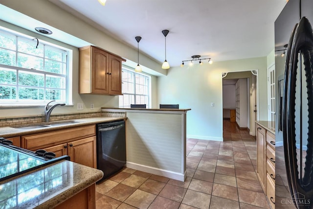 10730 Adventure Ln, Montgomery, OH 45242 - kitchen with black appliances, hanging light fixtures, brown cabinetry, a peninsula, and light countertops