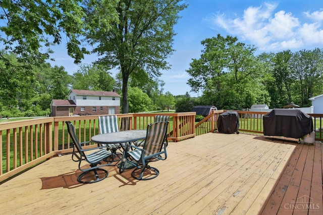 1704 Ludlow Cir, Pierce Twp, OH 45102 - deck with grilling area, outdoor dining area, view of wooded area, and a lawn
