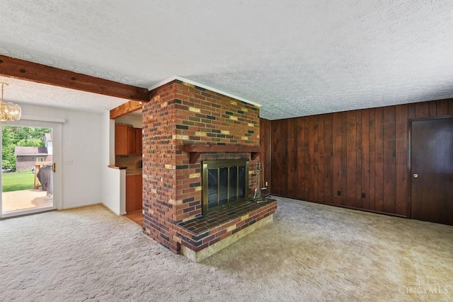 1704 Ludlow Cir, Pierce Twp, OH 45102 - unfurnished living room with a textured ceiling, carpet flooring, a fireplace, wood walls, and a chandelier