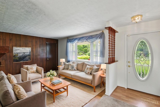 1704 Ludlow Cir, Pierce Twp, OH 45102 - living area with light wood-style flooring, wooden walls, and a textured ceiling