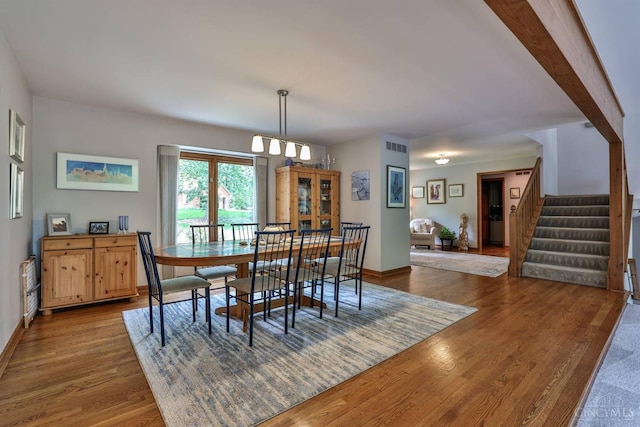 9396 Kemper Grove Ln, Symmes Twp, OH 45140 - dining area with wood finished floors, stairway, and a chandelier