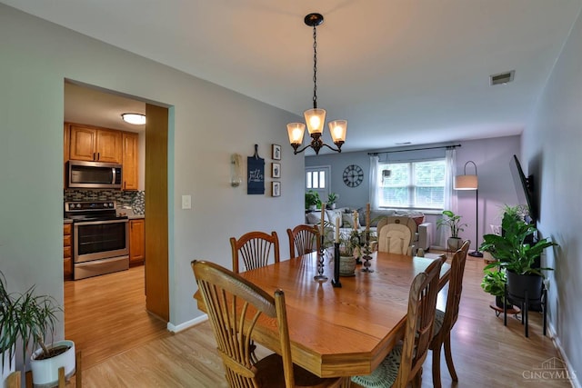 10569 Gloria Ave, Cincinnati, OH 45231 - dining space featuring light wood finished floors and a chandelier