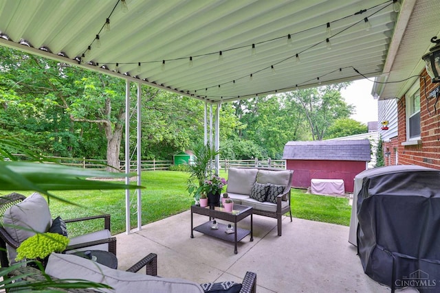 10569 Gloria Ave, Cincinnati, OH 45231 - fenced backyard with outdoor lounge area, a storage shed, a patio area, a grill, and view of wooded area