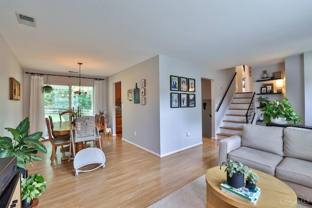 10569 Gloria Ave, Cincinnati, OH 45231 - living room featuring light wood finished floors, stairway, and a chandelier