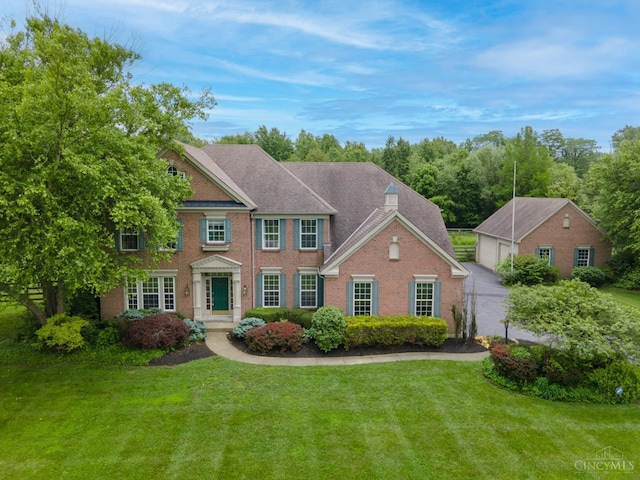 7194 Orchard View Ln, Salem Twp, OH 45152 - colonial inspired home with a front lawn, a garage, and brick siding