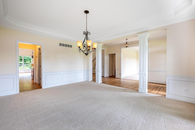 7194 Orchard View Ln, Salem Twp, OH 45152 - carpeted empty room featuring ornamental molding, ornate columns, a chandelier, wainscoting, and a decorative wall