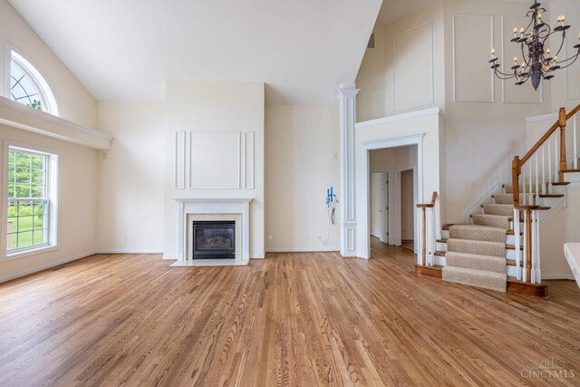 7194 Orchard View Ln, Salem Twp, OH 45152 - unfurnished living room with light wood-style floors, stairway, a chandelier, and a fireplace with flush hearth