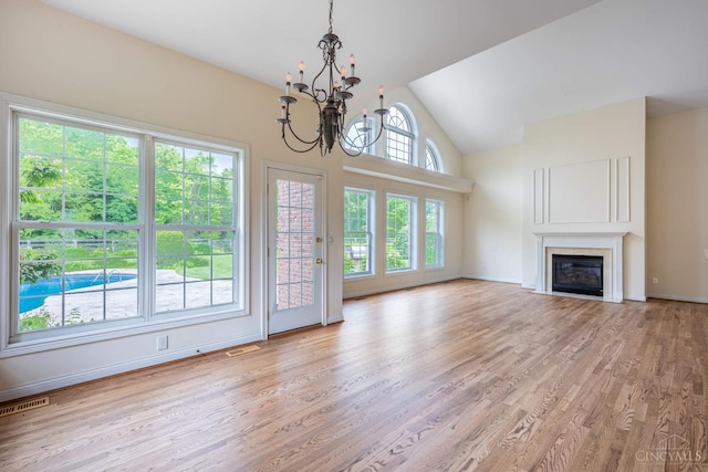 7194 Orchard View Ln, Salem Twp, OH 45152 - unfurnished living room featuring a chandelier, light wood-style flooring, a glass covered fireplace, and high vaulted ceiling