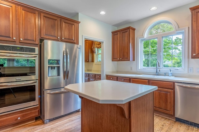 7194 Orchard View Ln, Salem Twp, OH 45152 - kitchen with appliances with stainless steel finishes, light wood-style flooring, a center island, light countertops, and brown cabinets