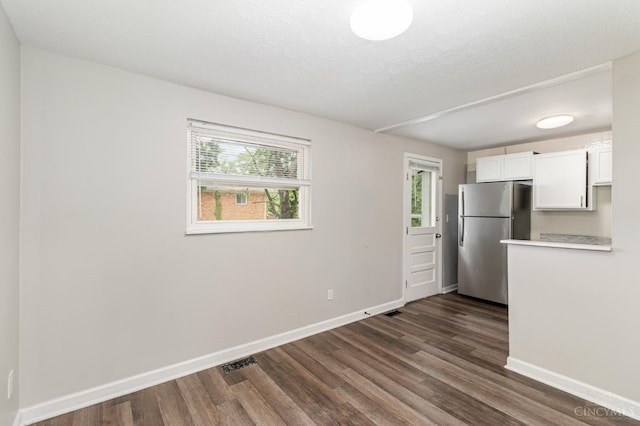 9733 Gertrude Ln, Springfield Twp, OH 45231 - kitchen with freestanding refrigerator, dark wood finished floors, white cabinetry, light countertops, and a textured ceiling