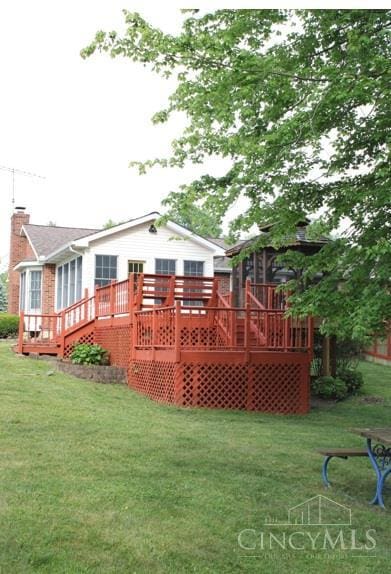 10 Chippewa Cv, Sardinia, OH 45171 - back of property featuring a deck, a lawn, a chimney, and a sunroom