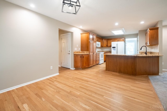 1606 Thall Dr, Hamilton, OH 45013 - kitchen with white appliances, light wood finished floors, a peninsula, recessed lighting, and light stone countertops