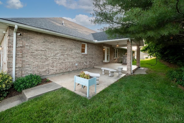1606 Thall Dr, Hamilton, OH 45013 - rear view of house with a patio area, a lawn, brick siding, and a shingled roof