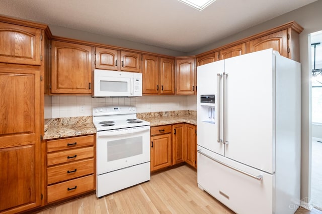 1606 Thall Dr, Hamilton, OH 45013 - kitchen with white appliances, light wood-style floors, brown cabinetry, tasteful backsplash, and light stone counters