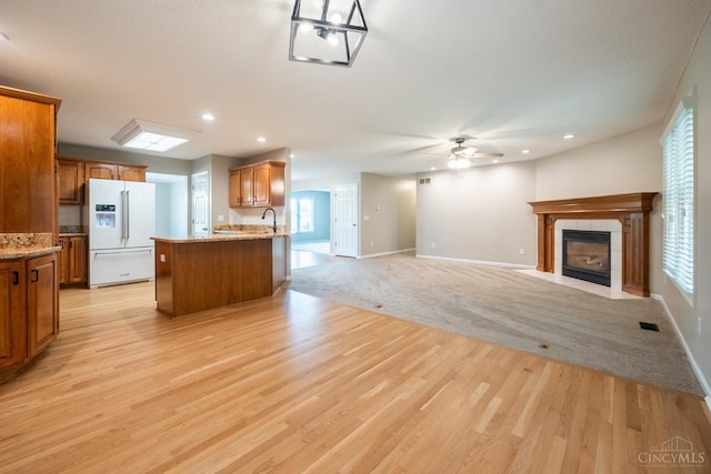 1606 Thall Dr, Hamilton, OH 45013 - kitchen featuring white fridge with ice dispenser, ceiling fan, open floor plan, a tile fireplace, and recessed lighting