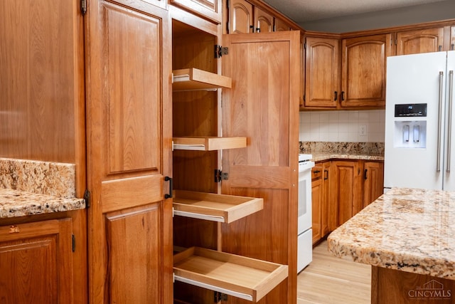 1606 Thall Dr, Hamilton, OH 45013 - kitchen featuring white appliances, open shelves, brown cabinets, decorative backsplash, and light stone counters