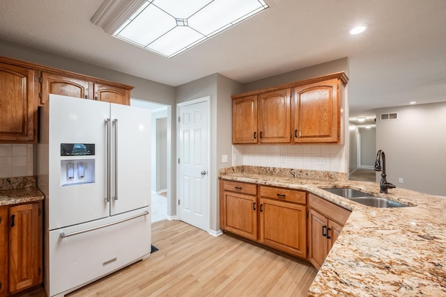 1606 Thall Dr, Hamilton, OH 45013 - kitchen featuring white fridge with ice dispenser, light wood-style flooring, decorative backsplash, brown cabinets, and recessed lighting