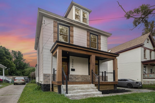 3846 Davis Ave, Cheviot, OH 45211 - american foursquare style home featuring a porch and stone siding