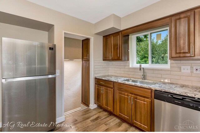 1502 Shenandoah, Cincinnati, OH 45237 - kitchen with appliances with stainless steel finishes, light stone countertops, tasteful backsplash, and light wood-style flooring