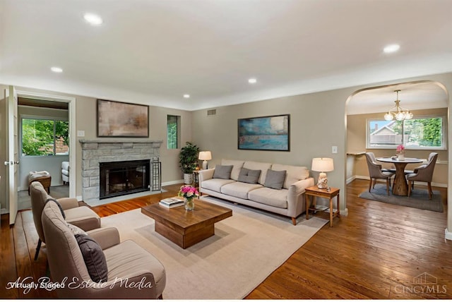 1502 Shenandoah, Cincinnati, OH 45237 - living room featuring a chandelier, arched walkways, wood-type flooring, a stone fireplace, and recessed lighting