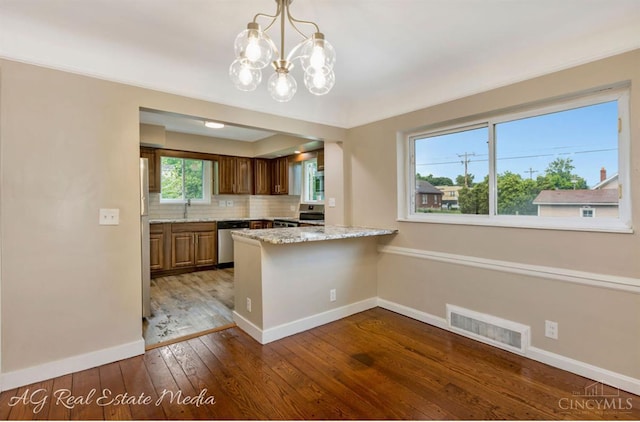 1502 Shenandoah, Cincinnati, OH 45237 - kitchen featuring appliances with stainless steel finishes, a peninsula, hardwood / wood-style floors, a chandelier, and decorative backsplash