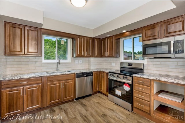 1502 Shenandoah, Cincinnati, OH 45237 - kitchen featuring appliances with stainless steel finishes, light wood-style floors, light stone counters, backsplash, and brown cabinetry