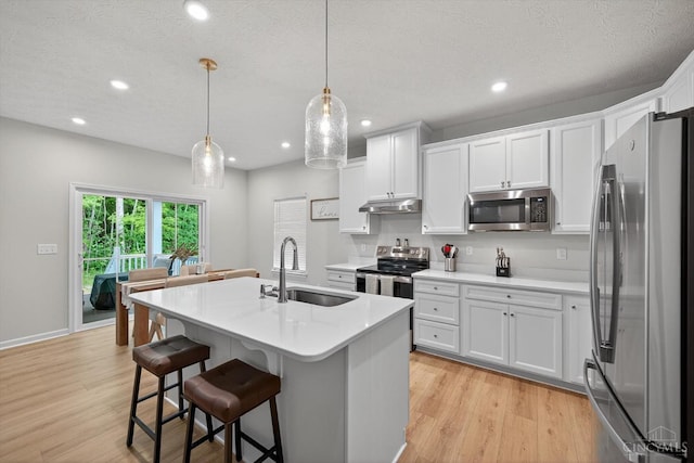 1285 Millstream Dr, Batavia Twp, OH 45102 - kitchen with stainless steel appliances, under cabinet range hood, recessed lighting, light countertops, and white cabinets