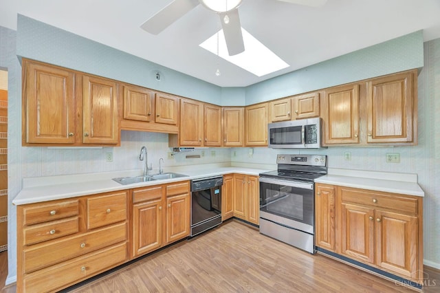 5505 Goldcrest Dr, Green Twp, OH 45238 - kitchen featuring appliances with stainless steel finishes, a skylight, a ceiling fan, light wood-style floors, and light countertops