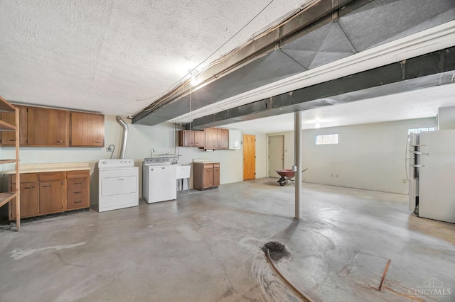 5505 Goldcrest Dr, Green Twp, OH 45238 - below grade area with washing machine and clothes dryer, freestanding refrigerator, and a textured ceiling