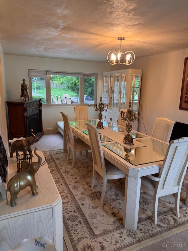 3969 S Fordham Pl, Silverton, OH 45213 - dining room featuring a chandelier, a fireplace, and light colored carpet