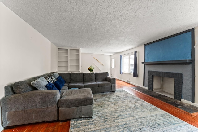 405 Hyde Park Dr, Hamilton, OH 45013 - living area with wood finished floors, a textured ceiling, a fireplace, and built in shelves