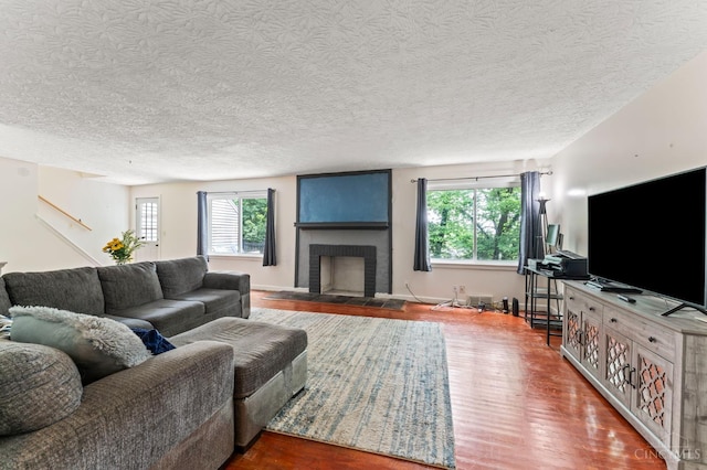 405 Hyde Park Dr, Hamilton, OH 45013 - living room with healthy amount of natural light, wood finished floors, a fireplace, and a textured ceiling