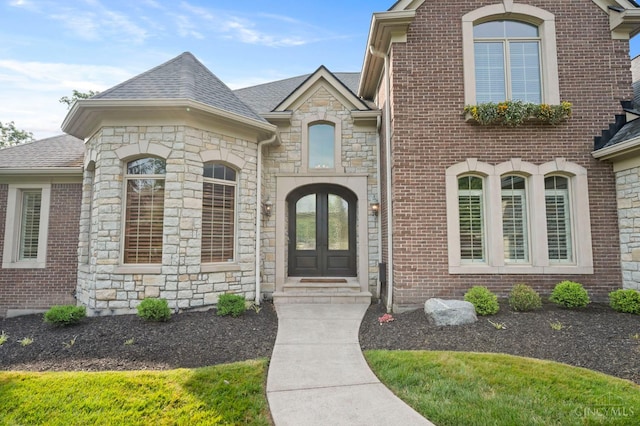 9317 E Kemper Rd, Symmes Twp, OH 45140 - view of front of home featuring stone siding, french doors, a shingled roof, and brick siding