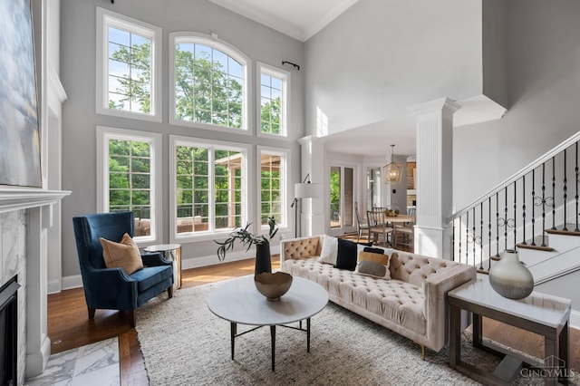 9317 E Kemper Rd, Symmes Twp, OH 45140 - living area with a towering ceiling, a premium fireplace, ornamental molding, stairs, and decorative columns