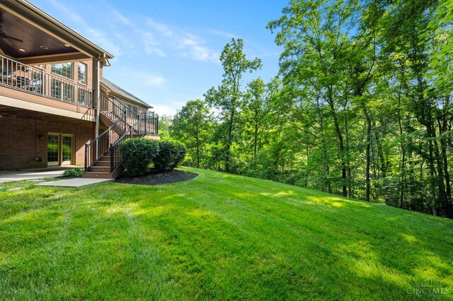 9317 E Kemper Rd, Symmes Twp, OH 45140 - view of green lawn with stairs, a patio, a wooden deck, and a ceiling fan