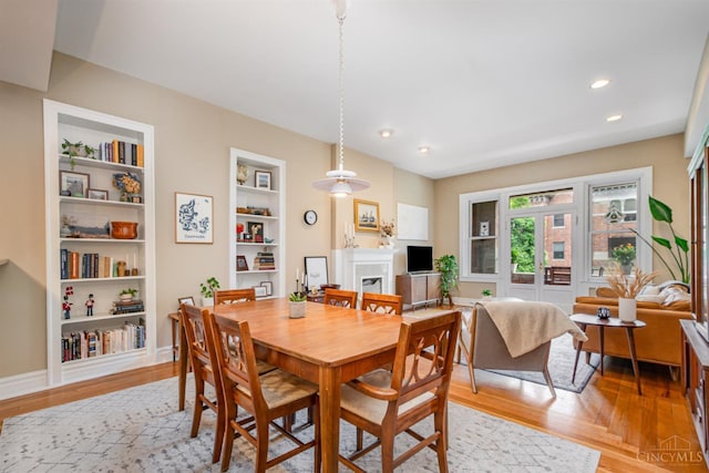 2356 Park Ave Unit 9, Cincinnati, OH 45206 - dining area featuring light wood finished floors, a fireplace, recessed lighting, and built in shelves