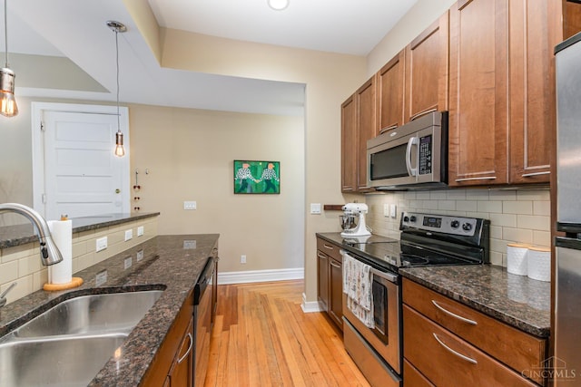 2356 Park Ave Unit 9, Cincinnati, OH 45206 - kitchen with appliances with stainless steel finishes, brown cabinets, light wood-style floors, and backsplash
