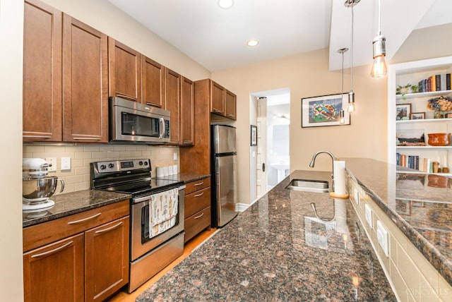 2356 Park Ave Unit 9, Cincinnati, OH 45206 - kitchen featuring stainless steel appliances, hanging light fixtures, brown cabinets, dark stone countertops, and backsplash