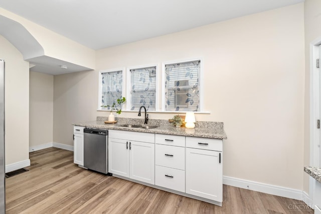 6213 Coleridge Ave, Cincinnati, OH 45213 - kitchen with stainless steel dishwasher, light wood-style floors, light stone countertops, and white cabinetry