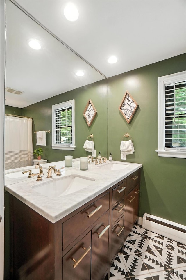 3862 Settle Rd, Mariemont, OH 45227 - full bath featuring baseboard heating, double vanity, tile patterned floors, plenty of natural light, and recessed lighting
