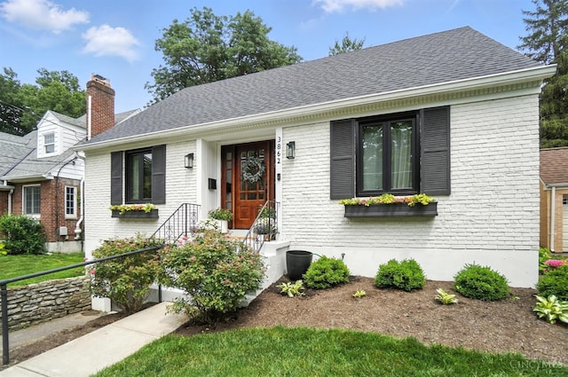 3862 Settle Rd, Mariemont, OH 45227 - view of front of house with brick siding, roof with shingles, and a chimney
