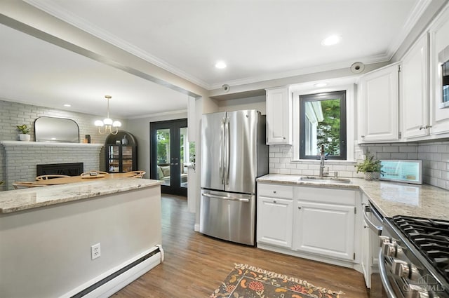 3862 Settle Rd, Mariemont, OH 45227 - kitchen featuring appliances with stainless steel finishes, a baseboard heating unit, white cabinetry, wood finished floors, and crown molding