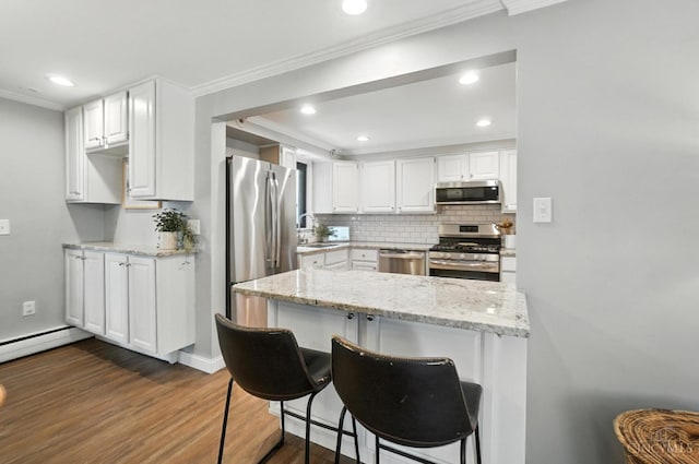 3862 Settle Rd, Mariemont, OH 45227 - kitchen featuring appliances with stainless steel finishes, crown molding, dark wood-type flooring, backsplash, and light stone counters