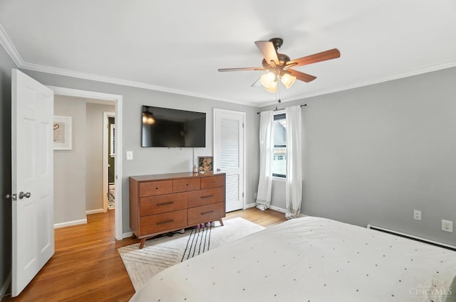 3862 Settle Rd, Mariemont, OH 45227 - bedroom with light wood-style flooring, crown molding, a ceiling fan, and a baseboard heating unit