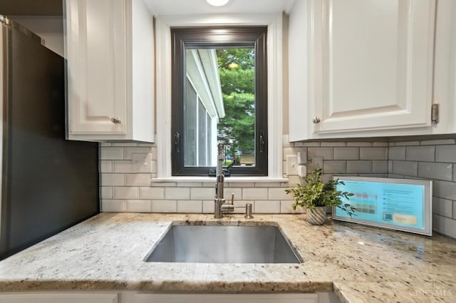 3862 Settle Rd, Mariemont, OH 45227 - kitchen featuring decorative backsplash, light stone counters, white cabinetry, and freestanding refrigerator
