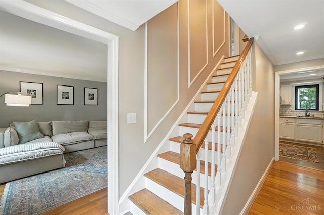 3862 Settle Rd, Mariemont, OH 45227 - staircase with wood finished floors, crown molding, and recessed lighting