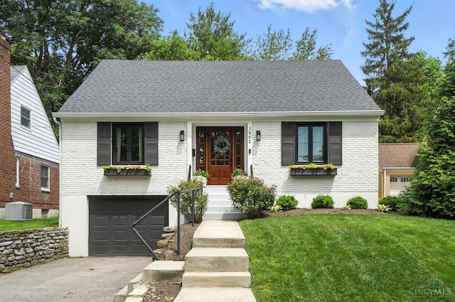 3862 Settle Rd, Mariemont, OH 45227 - view of front of home featuring brick siding, asphalt driveway, a front lawn, a garage, and a shingled roof