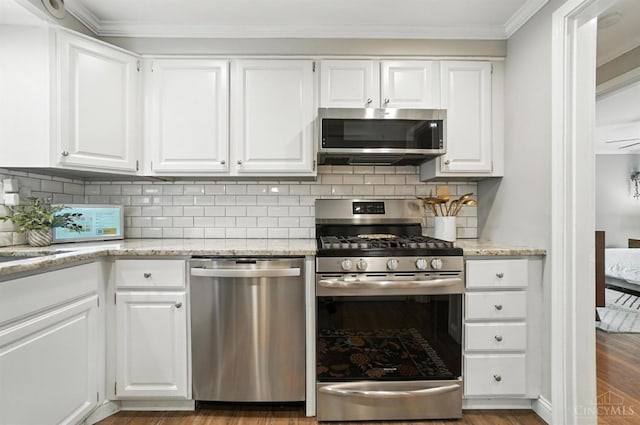 3862 Settle Rd, Mariemont, OH 45227 - kitchen featuring stainless steel appliances, white cabinetry, decorative backsplash, and crown molding