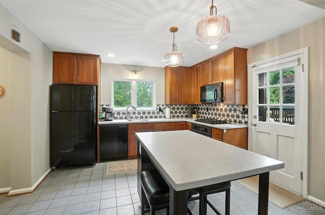 6159 Tulane Rd, Cincinnati, OH 45212 - kitchen with black appliances, light countertops, backsplash, brown cabinets, and pendant lighting