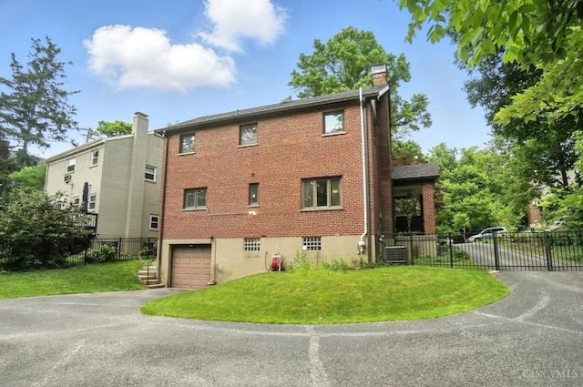 6159 Tulane Rd, Cincinnati, OH 45212 - view of side of property featuring a chimney, driveway, brick siding, and a garage